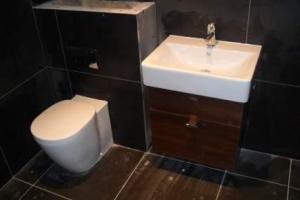 The new bathroom and shower room is modern, with strong, clean lines and dark colours.  from project Rush Renovation